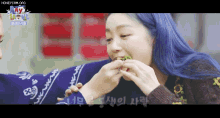 a woman with blue hair is eating a sandwich with the words honeycam.org at the top of the screen