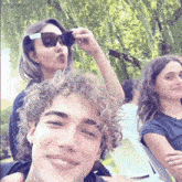 a group of people are posing for a picture and one of them has sunglasses on