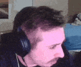 a man wearing headphones is sitting in front of a computer monitor .