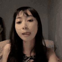 a woman sticking her tongue out while sitting on a bed