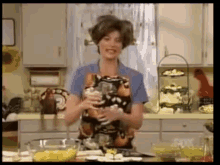 a woman is standing in a kitchen holding a glass of wine