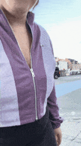 a woman wearing a purple jacket with a zipper