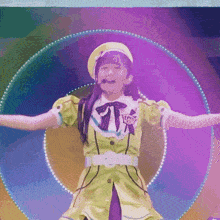 a girl wearing a yellow hat and a green dress with the letter w on the sleeve