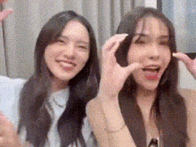 two young women are sitting next to each other making funny faces .