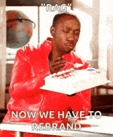 a man in a red jacket is eating a cake with a spoon .
