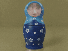 a blue green and orange matryoshka doll with flowers on them