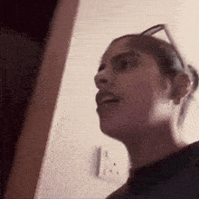 a woman wearing glasses is standing in front of a door