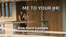 a woman is holding a baby on a balcony while talking to a man .