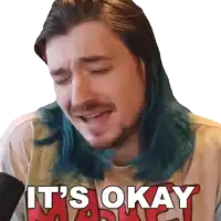 a man with blue hair and a beard is wearing a shirt that says it 's okay