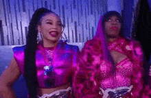 two women are standing next to each other in a room .