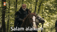 a man riding a horse in a forest with the words salam alaikum written below him