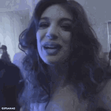 a woman with long hair is making a funny face and sticking her tongue out at the camera .
