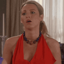 a woman wearing a red dress and a blue necklace