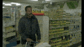 a man is pushing a shopping cart in a store with a sign that says star