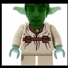 a lego figure has a green face and a white shirt