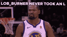 a man in a golden state warriors jersey is standing in front of a basketball hoop .
