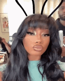 a woman with bunny ears on her head is making a funny face