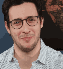 a man wearing glasses and a polka dot shirt makes a funny face