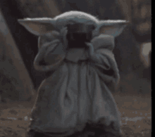 a baby yoda from star wars is holding a book