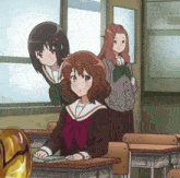 a girl in a school uniform sits at a desk in a classroom with other girls