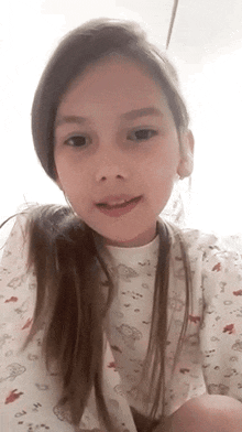 a young girl with long hair is smiling for the camera