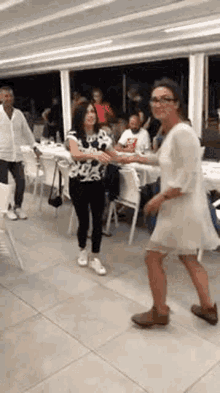 a group of women are dancing together in a room .