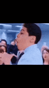 a young boy is holding a microphone in front of a crowd of people .