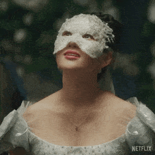 a woman is wearing a white mask and a necklace with netflix written on the bottom