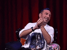 a man with purple hair is wearing a white t-shirt with a picture of a cat on it