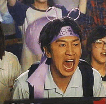 a man wearing bunny ears and a headband with chinese writing on it