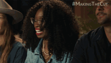 a woman with curly hair and glasses is smiling in a making the cut ad