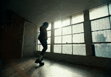 a person standing in front of a window with a grid pattern