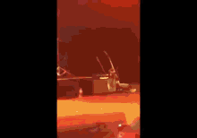 a man is singing into a microphone on a stage with drums in the background