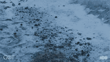 a man with a beard is standing in the snow wearing a black coat .