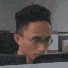 a man with glasses is looking at something
