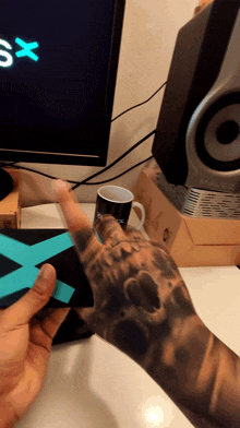 a person with a tattoo on their arm is holding a piece of paper that says xsx