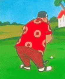 a man wearing a red shirt with circles on it is playing golf