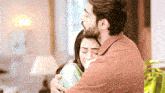 a man is hugging a woman in a living room in a room .