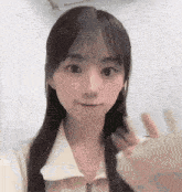 a young woman with long hair and bangs is making a funny face and waving .