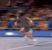 a man is running on a tennis court with a racket in his hand