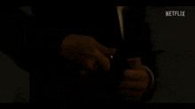 a man in a suit and white shirt is standing in a dark room .
