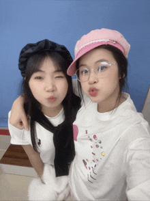 two girls are posing for a picture and one is wearing a shirt that says hello kitty on it