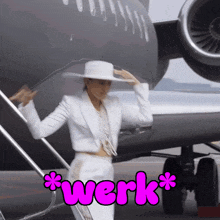 a woman in a white suit is standing on the steps of an airplane with the word werk written in pink