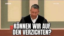 a judge is sitting in a courtroom with a book in front of him and says `` können wir auf den verpflichten ? ''