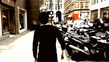 a man walking down a street with a sign that says ' a ' on it