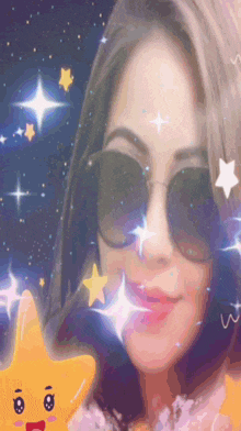 a woman wearing sunglasses holds a yellow star with a face on it