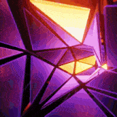 a computer generated image of purple and yellow triangles in a dark room