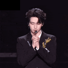 a man wearing a black jacket with the word gucci on the front