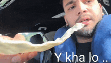a man in a car eating a tortilla with the words y kha lo written below him
