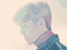 a close up of a man 's face with a pink turtleneck
